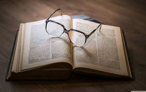 Glasses On Open Book Wallpaper