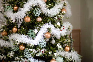 Glowing Christmas Tree In A Cozy Living Room Wallpaper