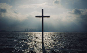 Glowing Cross In Dark Clouds Wallpaper