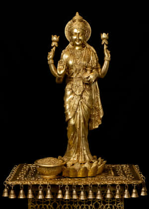 Golden Lakshmi Statueon Pedestal Wallpaper