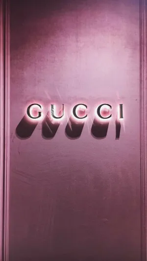 Gucci Logo On A Pink Wall Wallpaper