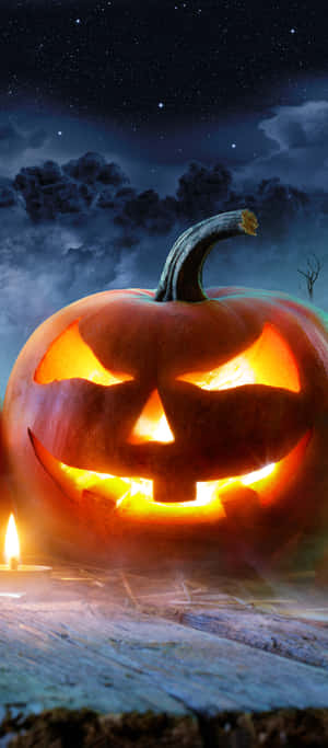Halloween Pumpkin Glowing Under Starry Sky Wallpaper