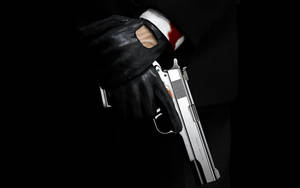 Hitman Hand Holding His Handgun Wallpaper