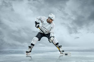 Ice Hockey Player Hitting The Puck Wallpaper