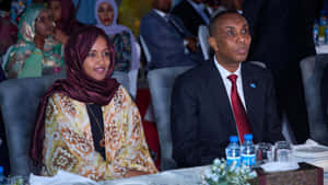 Ilhan Omar Beside A Man Wallpaper