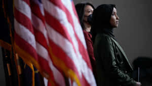Ilhan Omar Beside The Us Flag Wallpaper