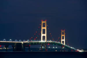 Illuminated Mackinac Bridge Under Starry Night Wallpaper