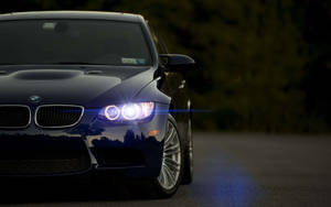 Image A Sleek Black Bmw Car Against A High-definition City Skyline. Wallpaper