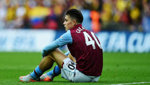 Jack Grealish Sitting On Ground Wallpaper