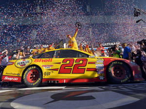 Joey Logano Celebrating His Victory With Confetti At The Race Track Wallpaper