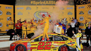 Joey Logano Celebrating Victory With His Team Wallpaper