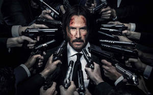 John Wick Fires Guns In An Action Packed Showdown Wallpaper