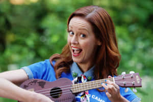 Joyful Ukulele Player Outdoors Wallpaper