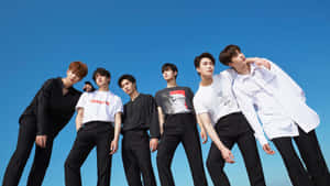 K Pop_ Group_ Astro_ Posing_ Against_ Blue_ Sky Wallpaper