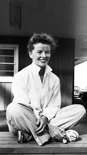 Katharine Hepburn Seated On A Wooden Floor Wallpaper