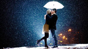 Korean Couple Kissing Amid Snowfall Wallpaper