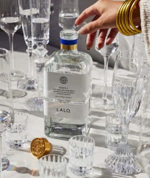 Lalo Tequila Bottle Among Crystal Glasses Wallpaper
