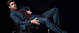 Liam Hemsworth Sitting On Black Background Wallpaper