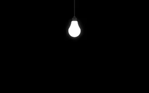 Light Bulb In Solid Black Room Wallpaper