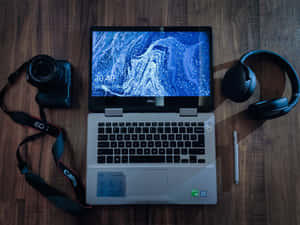 Listen Up And Tune In With A Laptop And Headphones Wallpaper