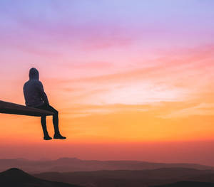 Lonely Guy Watching Orange Sunset Wallpaper