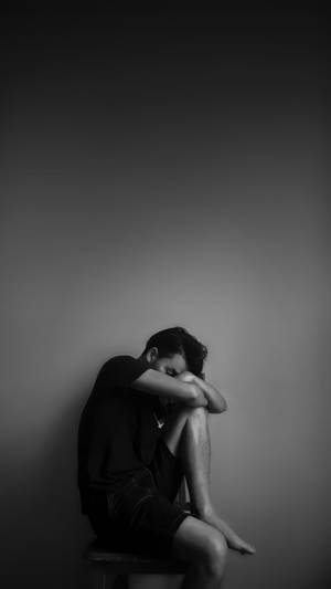 Lonely Man Leaning Against A Wall Wallpaper