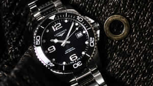 Longines Hydroconquest Watch Placed On A Fabric Wallpaper