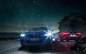 Luxurious Blue Bmw Driving At Night Wallpaper