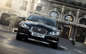 Luxury On Display: Jaguar Car At The Iconic Hotel De Paris Wallpaper