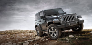 Majestic Black Jeep Wrangler Highlighted By A Striking Silver Logo Wallpaper