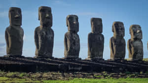 Majestic Moai Statues Cast Shadows At Sunset Wallpaper