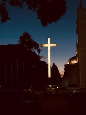 Majestic Wooden Cross Against Sunrise Sky Wallpaper