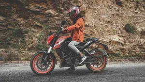Man Driving A Ktm Duke 200 Wallpaper