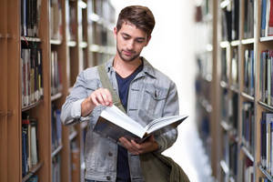 Man Flipping Through A Reference Book Wallpaper