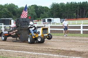 Man Operating A Yellow Tractor In The Field Wallpaper