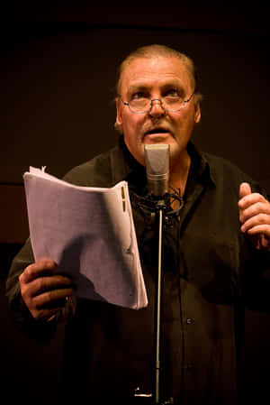 Man Reading Scriptat Microphone Wallpaper