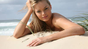 Margot Robbie Lying On Beach Sand Wallpaper