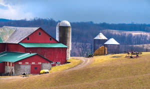 Massive Red Barn In Farm With Large Silo Wallpaper