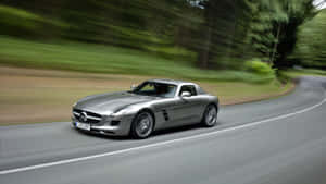 Mercedes Sls Amg Driving Down A Road Wallpaper