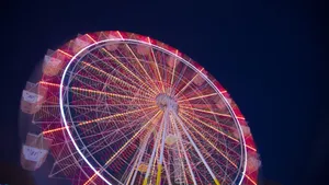 Mesmerizing Display Of Neon Lights On Ferris Wheel Wallpaper