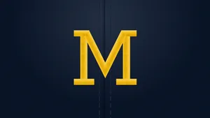 Michigan Wolverines Logo On A Football Field Wallpaper