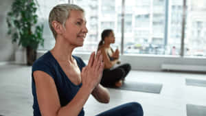 Middle Aged Woman Yoga Session Wallpaper