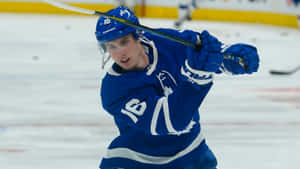 Mitchell Marner Hitting A Puck Wallpaper