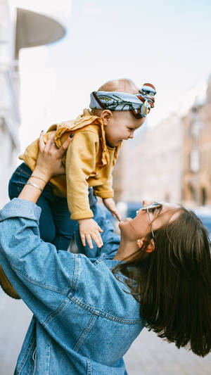 Mom Lifting Baby Wallpaper