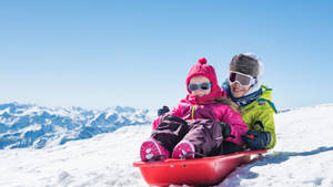 Mother And Daughter Sledding Bond Wallpaper