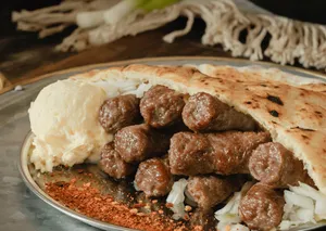 Mouthwatering Grilled Ćevapi Served With Chili Flakes Wallpaper