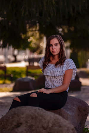 Mujer Madura Sitting On Boulders Wallpaper