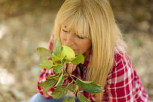 Mujer Madura Smelling Plants Wallpaper