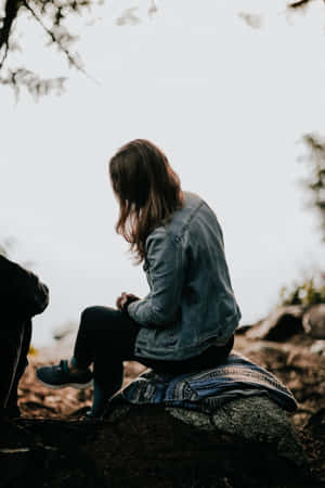 Mujer Soltera Sitting On A Rock Wallpaper