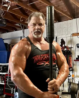 Muscled Manin Gym Holding Weighted Bar Wallpaper